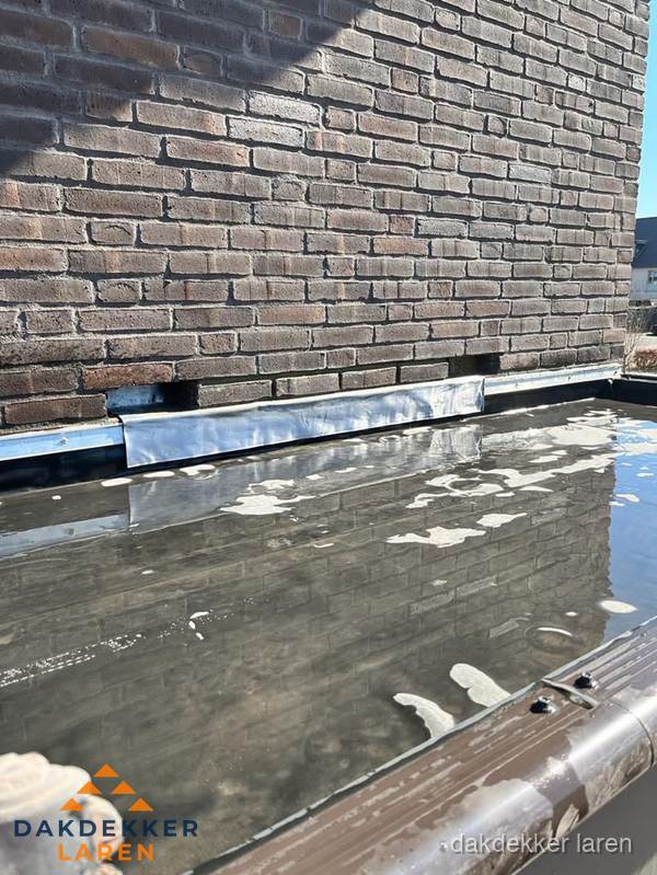 Stilstaand water op plat dak door slechte afwatering in Laren Stilstaand water op plat dak door slechte afwatering in Laren