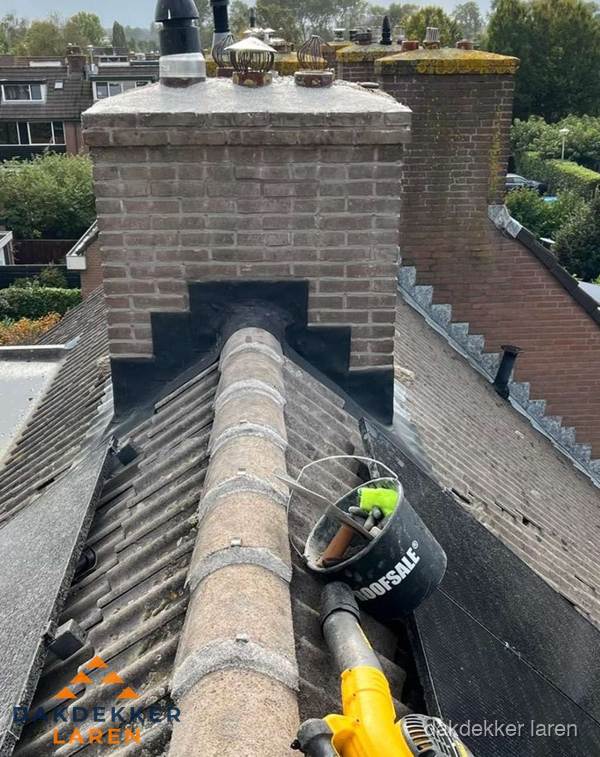 Schoorsteen met loodaansluiting en nokvorst op pannendak in Laren Schoorsteen met loodaansluiting en nokvorst op pannendak in Laren