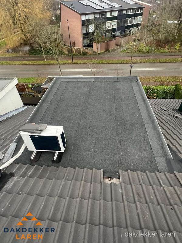 Plat dak inspectie met bitumen bedekking naast schuin pannendak in Laren Plat dak inspectie met bitumen bedekking naast schuin pannendak in Laren