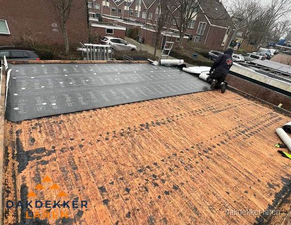 Dakdekker legt onderlaag op plat dak met houten constructie in Laren Dakdekker legt onderlaag op plat dak met houten constructie in Laren